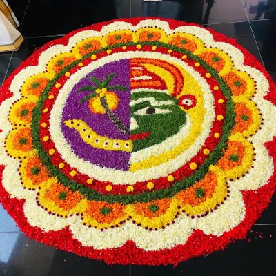 An example of our detailed Pookkalam work, combining the faces of Kathakali and Maveli with coconut tree motifs. We can create custom designs that reflect the themes of your Onam event.
