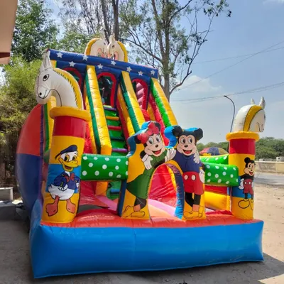 Here is a classic Mickey and Friends bouncy slide. It has Mickey, Minnie, and Donald Duck, with fun horse figures on the side. The bright colors make it a cheerful centerpiece for any birthday party.