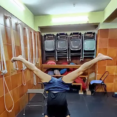 A variation of Sirsasana (Headstand) with legs in Upavistha Konasana. This advanced inversion requires significant core strength, balance, and concentration.