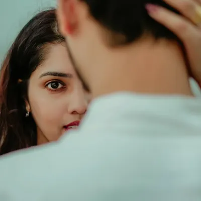 A beautifully composed shot focusing on the bride-to-be's expressive eyes. This intimate portrait of Jayashree captures a moment of quiet connection and love.
