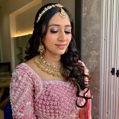A beautiful pink glam look. The makeup features a shimmery pink eyeshadow and a flawless base, perfect for any festive occasion.