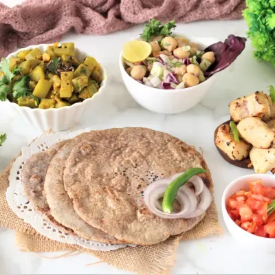 This is a typical vegetarian meal, featuring multigrain bhakri, a seasonal vegetable preparation, high-protein paneer, and a fresh chickpea salad. It’s a complete, balanced office lunch that provides sustained energy.