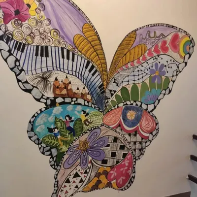 This large, hand-painted butterfly mural is a great example of our custom doodle art. We fill the design with intricate patterns, from piano keys to floral motifs, creating a unique piece of art that becomes a conversation starter.
