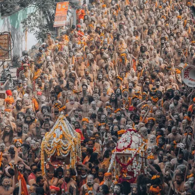 A ground-level photograph of the Naga Sadhus at the Kumbh Mela in Haridwar. This is not an aerial shot, but a close, respectful portrait of their procession, capturing the intensity and spiritual power of these ascetics.