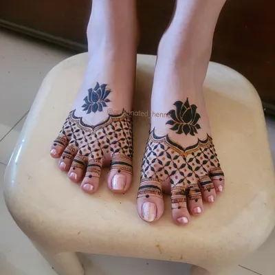 This is a clean and dainty feet henna design, featuring bold lotus motifs that stand out against a delicate grid pattern. It’s a perfect complement to any bridal or party look.
