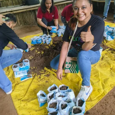 A volunteer from KPMG gives a thumbs-up during a stem cutting activity. Our workshops are hands-on, teaching skills that participants can use in their own homes and communities.