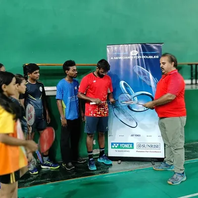 I believe in using the best equipment. Here, I am explaining the features of a new Yonex Astrox racquet to my players during a demo day.