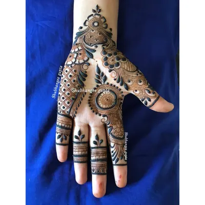 A beautiful and modern designer mehndi piece. This style uses a mix of bold strokes, delicate vines, and a central mandala to create a flowing design that is both traditional and contemporary.