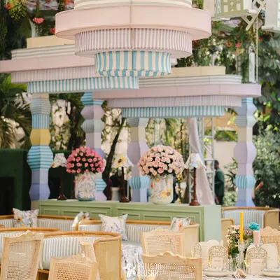 This image showcases our ability to create large, impactful structures that define a space. This custom-built pastel-striped canopy and pillar installation became the architectural heart of this whimsical garden-themed event.