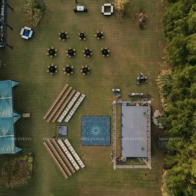 A 360-degree aerial view of a complete event setup. This shot showcases our precision in planning, with distinct zones for the stage, dance floor, lounge seating, and dining canopies all arranged perfectly.