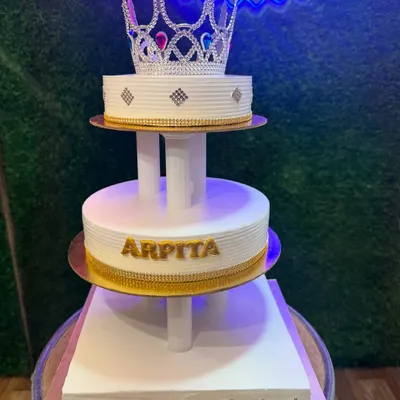 This magnificent three-tier cake with a sparkling crown topper is fit for royalty. The clean white design with gold accents creates a look of pure elegance, perfect for a grand birthday or wedding celebration.