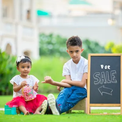 A perfect example of sibling humor. This big brother's playful pose and the funny sign add so much personality to this outdoor portrait with his little sister.