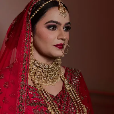 A close up of a regal bride. The focus here was on creating a bold, classic red lip and dramatic smokey eyes to match her magnificent gold jewelry.