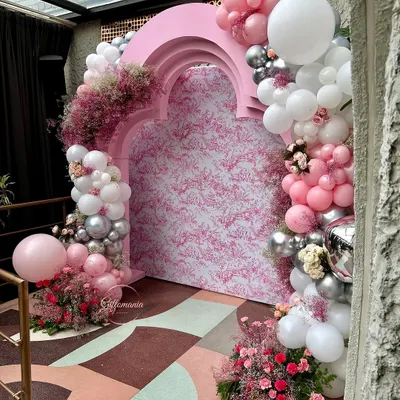 The main photo backdrop for a 40th birthday party with a Dior-inspired theme. The design features a custom-printed panel inside a pink arched structure, surrounded by a lush garland of pink, white, and silver balloons.