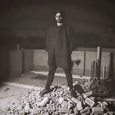 Standing on a pile of rubble, a metaphor for building something new from the ground up. This shot captures the raw, industrial edge of my techno sound.