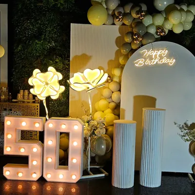 Celebrating a 50th birthday calls for something special and elegant. This setup features a classy white and gold theme with marquee numbers, a custom neon sign, and soft lighting to create a sophisticated atmosphere.