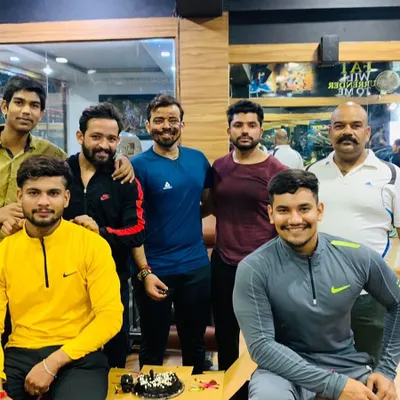 The whole crew comes together to celebrate. This is what our gym family looks like, sharing smiles and cake after a good workout session.