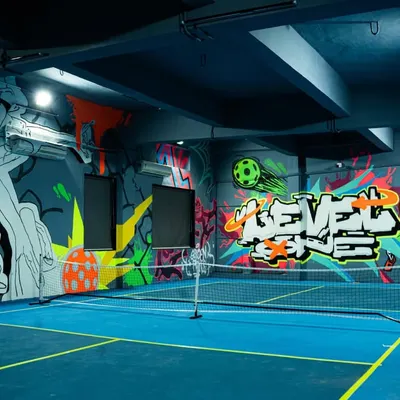 This is the Level One Arena pickleball court under normal lighting. You can see the full composition of the sports-themed graffiti, designed to be vibrant and energetic even before the blacklights are turned on.