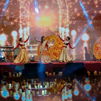 For this 'Chandni Ratein' Sufi-themed sangeet, we used paisley-shaped props and a warm, golden color palette to create a rich and traditional atmosphere. The stage was lit with hundreds of candles to enhance the theme.