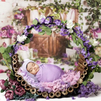 This peaceful newborn is resting in a floral hoop, surrounded by soft purple flowers. We designed this setup for an at-home session in Jaipur, bringing all the props to ensure the baby and mom are comfortable.