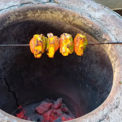 Paneer and bell peppers marinating on a skewer, ready to be cooked in a traditional tandoor for that authentic smoky flavor.