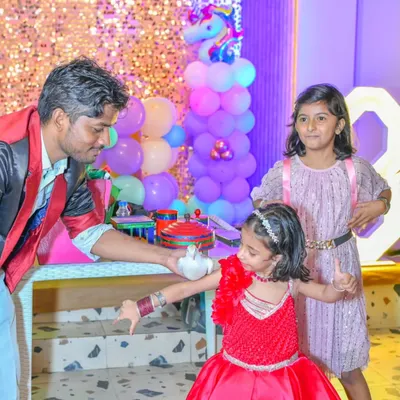 A magician captivates young guests with a live dove trick during a unicorn-themed party. A magic show is a fantastic add-on to keep everyone entertained.