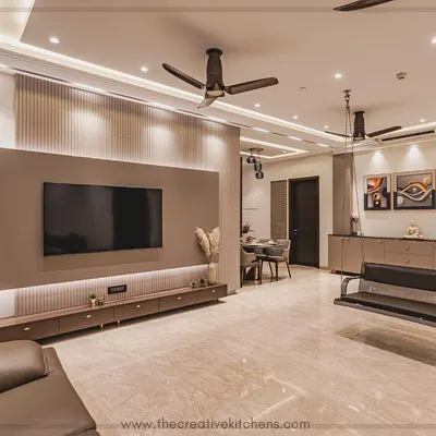 This living room is a serene escape, featuring a bespoke modular TV unit in a PU finish and a caffeinated color palette. The floating console and fluted back panel create a minimalist yet warm focal point for the entire space.