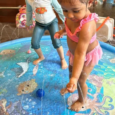 This little one is enjoying the gentle sprinklers in our splash pad. It's a perfect sensory activity for toddlers, especially on a warm day.