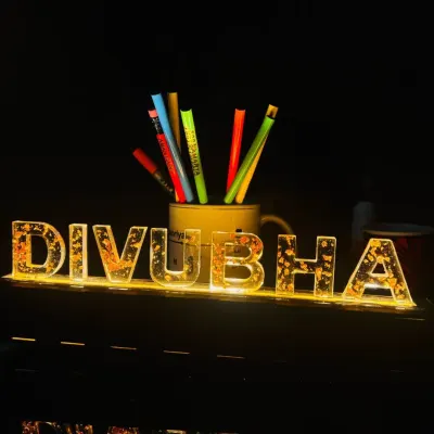 This custom LED name lamp is a stunning addition to any desk or room. The light shines through the acrylic letters, which are filled with gold flakes for an extra sparkle.