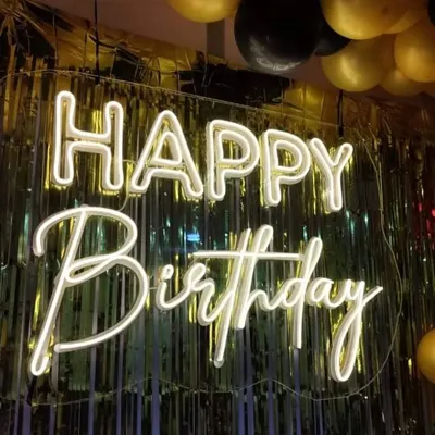 Our 'Happy Birthday' neon sign is one of our most popular rental items. It instantly brightens up any backdrop, like this golden foil curtain, and sets a festive mood.