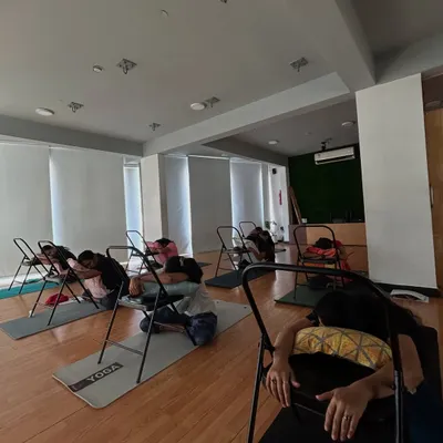 Members in our PCOD/PCOS workshop use chairs for a supported forward fold, a pose that helps calm the nervous system.