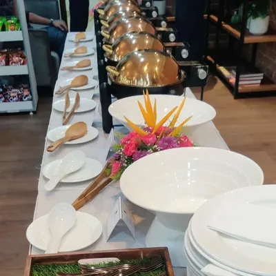 A full buffet line ready for a corporate office lunch. We provide a complete setup with professional chafing dishes, clean plating, and floral arrangements to make it feel like a special occasion.