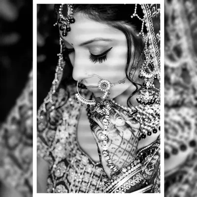 A black and white bridal portrait that emphasizes emotion and detail. This close-up focuses on the bride's intricate nath and henna, creating a classic, artistic photograph that feels timeless.