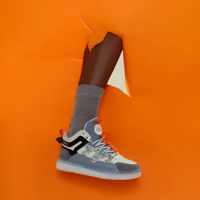 Breaking through the noise. This conceptual shot for a sneaker brand uses a torn paper effect to create a high-impact, memorable visual that's perfect for a campaign launch.