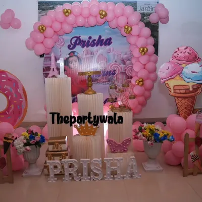 Welcome to Candyland! This sweet theme features giant donut and ice cream cutouts, a pink balloon arch, and candy-colored props. It's a delicious-looking setup for a fun birthday party.