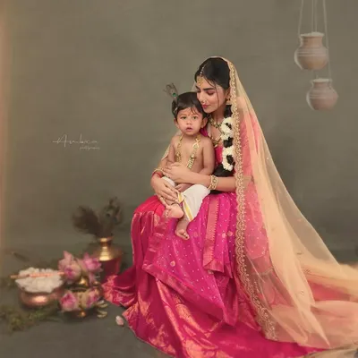 A mother and her little one recreating the iconic bond of Yashoda and Krishna. This painterly portrait, with its rich colors and emotional depth, is a perfect example of a fine art mythological session.