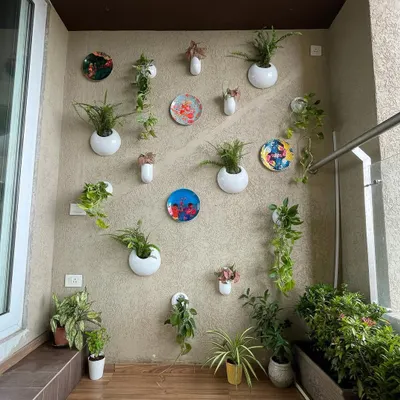 For this balcony, we used a creative mix of wall-mounted planters and decorative plates to create an artistic feature wall. This approach adds greenery without taking up any floor space, keeping the balcony open and uncluttered.
