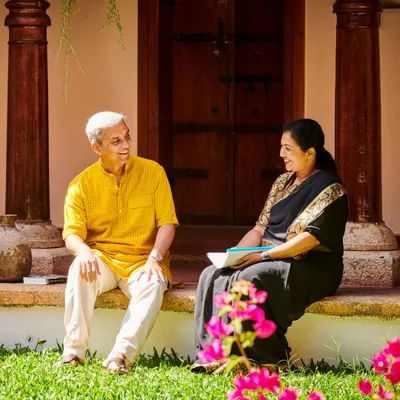 Two of our senior Ayurvedic doctors in conversation on the veranda of a heritage cottage. Their deep knowledge and compassionate approach guide your entire healing journey.