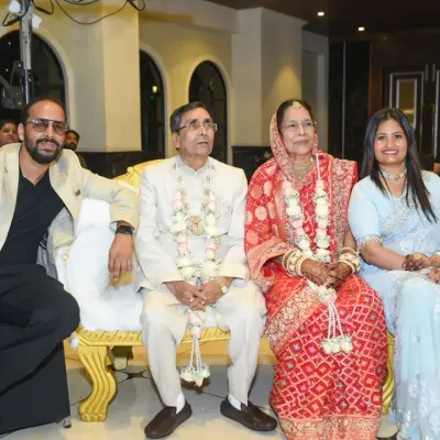 A beautiful family portrait from a 50th wedding anniversary celebration. The happy couple is seated on a grand sofa, surrounded by their children.