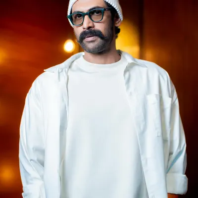 Styling Rana Daggubati in an all-white look for the brand Kingdom of White. This close-up shows the layering of a t-shirt and an open shirt, creating texture and depth within a single color.