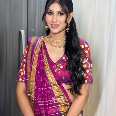 Serving a look that is both hot and pretty. This client is ready for her event in a traditional saree, paired with a modern ponytail, face-framing bangs, and a dewy makeup finish.