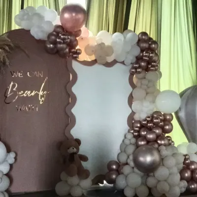 A close-up of my "We Can Bearly Wait" teddy bear theme. This shows the custom scalloped backdrop and a detailed organic balloon arch in rose gold, beige, and white, with a small teddy bear prop nestled in the balloons.