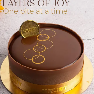 Layers of joy, one bite at a time. This is my classic Belgian chocolate truffle cake, featuring a perfect mirror glaze and our signature gold emblem, promising pure chocolate indulgence.