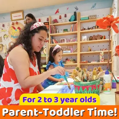 A mother and her toddler daughter painting together. Our parent-toddler time is all about shared experiences that enhance your child's sensorial and fine motor skills.