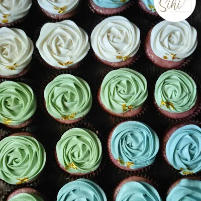 I love this color combination. These are my signature rosette cupcakes in shades of white, sage green, and sky blue, each dotted with a tiny flake of edible gold leaf.