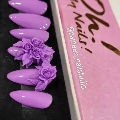 An example of a custom press-on nail set. This beautiful lilac design features two accent nails with incredibly detailed, hand-sculpted 3D rose bouquets.
