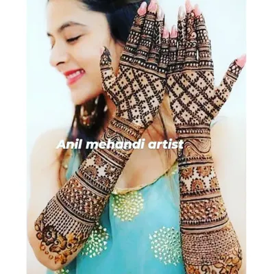 A happy client showing off her full-hand mehandi. The design features a classic criss-cross net pattern that looks stunning with the dark henna stain.