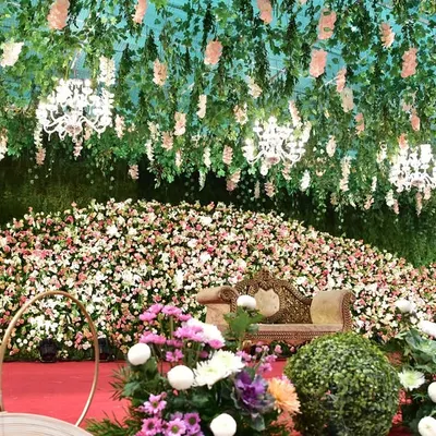 A closer look at the immense floral stage we created for a wedding reception. The sheer volume of flowers and the hanging floral ceiling with chandeliers made the entire venue feel like an enchanted garden.