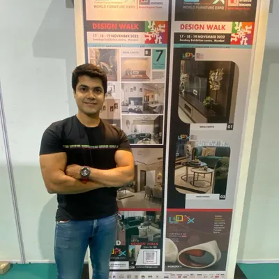 Nikhil Dhuri, co-founder, at the Design Walk exhibition by IIID Mumbai, standing proudly next to a display of our firm's work.