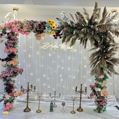 A stunning "Bride to be" decor setup. This beautiful arch combines lush florals with trendy pampas grass, all set against a fairy light curtain for a dreamy, bohemian vibe.
